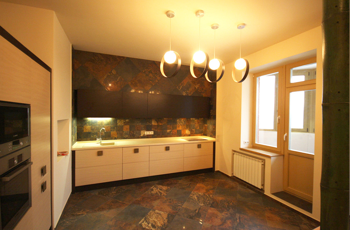 Стена и пол кухни по проекту имеют ярко выраженный природный характер за счет текстурного керамогранита с рисунком, имитирующим застывшую лаву.